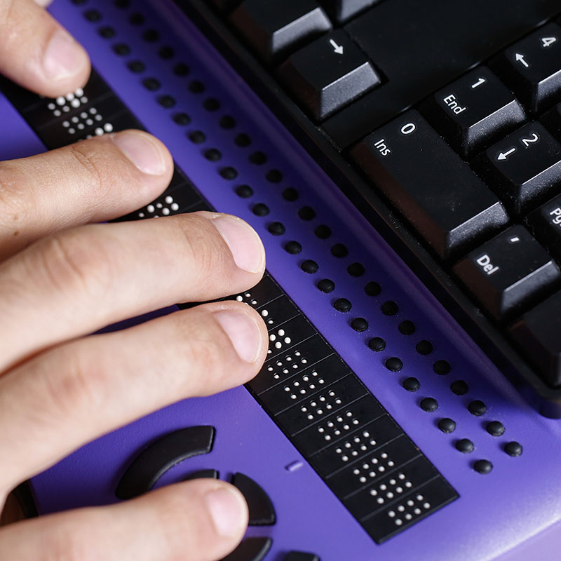 Blind person using computer Braille keyboard