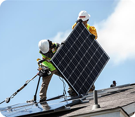A photo of crew installing solar panels on the roof